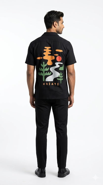 Person wearing a black t-shirt with colorful graphics on the back, standing against a white background
