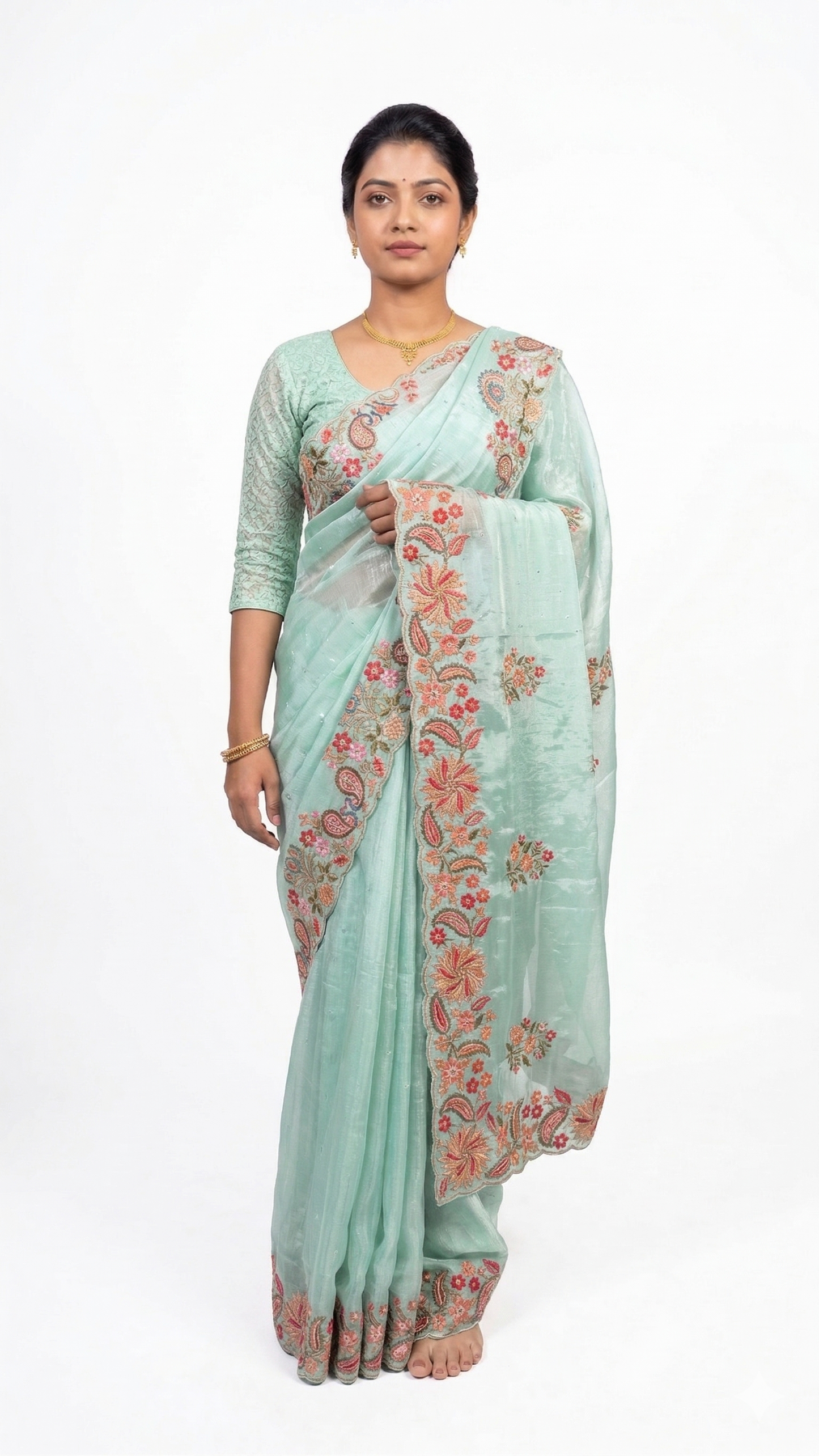 Woman wearing a light blue saree with floral patterns on a white background