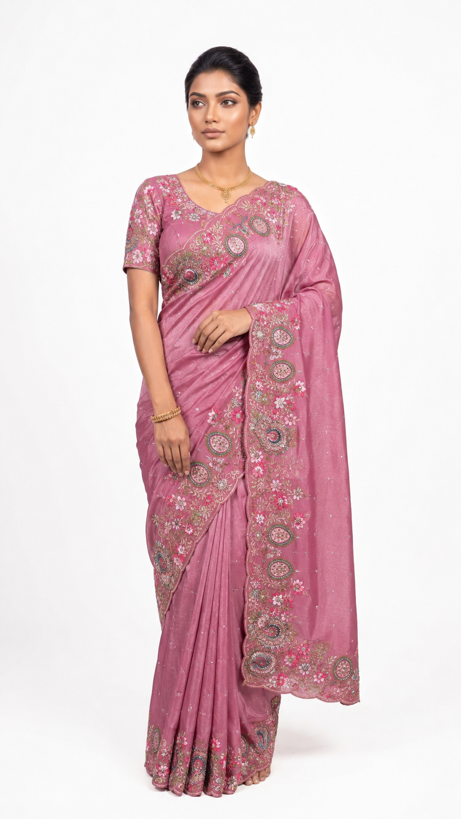 Woman wearing a pink saree with floral patterns on a white background